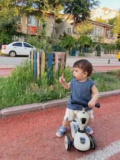 a little boy riding on top of a scooter