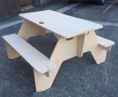 a wooden picnic table and bench sitting in a parking lot