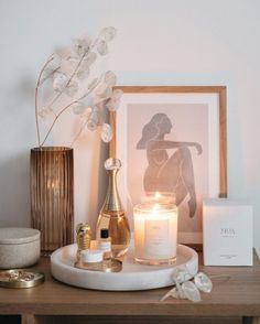 a table with candles, flowers and other items on it in front of a framed photo