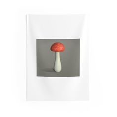 a red and white mushroom sitting on top of a white wall hanging from the side