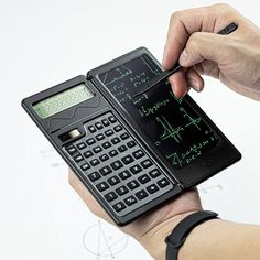 a person is holding a calculator and writing on the screen with a pen