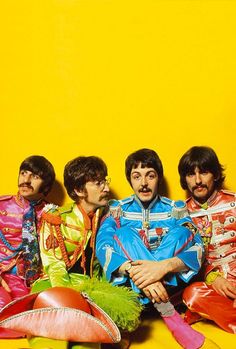 the beatles posing for a photo in front of a yellow wall with tomatoes and peppers