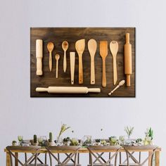 wooden utensils and spoons are arranged on a wall above a dining table