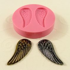 two angel wings sitting next to a pink plastic container