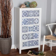 a blue and white chest of drawers next to a potted plant in a living room