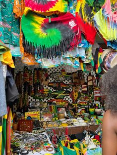 a woman standing in front of a store filled with colorful items