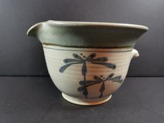 a ceramic vase with dragonflies painted on it