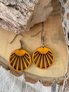 These Sunshine earrings will have you dreaming of the desert. These original designs are cut from Baltic birch, stained with an amber gold dye, and sealed with teak oil. Like all of our earrings, they are made with high quality, nickel free, hypoallergenic, components.. Measures 1.25” x 1.25”. Natural Wood Drop Earrings For Pierced Ears, Unique Brown Round Earrings, Nature-inspired Brown Jewelry With Matching Earrings, Hypoallergenic Brown Round Earrings, Natural Wood Nature-inspired Jewelry, Artisan Brown Pierced Earrings, Nature-inspired Brown Earrings With Ear Wire, Brown Dangle Earrings Nature-inspired, Nature-inspired Brown Dangle Earrings