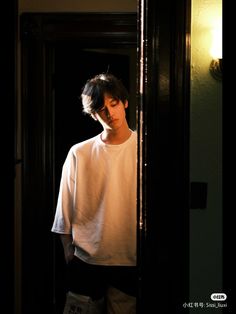 a young man standing in front of a doorway