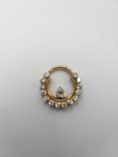 an image of a gold ring with pearls on the outside and inside it's center