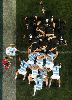 a group of people standing on top of a soccer field in the middle of a huddle