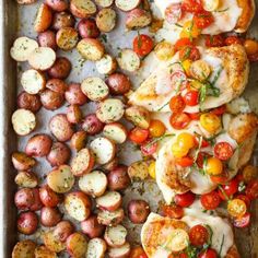 chicken, potatoes and tomatoes on a baking sheet