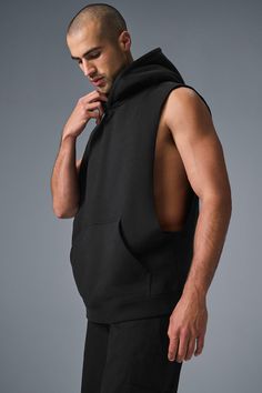 Stay cozy without sacrificing style in the Renown Sleeveless Hoodie. It has deep armholes, a kangaroo pocket, and a laid-back cut. And wait till you feel the Alo signature Renown fabric—it's smooth on the outside, a little fleecy on the side, and heavyweight for a just-right drape. Add shorts and you’re covered from the gym to the street. Athleisure Tops With Pockets For Streetwear, Black Tops With Kangaroo Pocket For Streetwear, Athleisure Hoodie With Pockets For Gym, Casual Black Activewear With Kangaroo Pocket, Urban Style Sleeveless Vest With Side Pockets, Black Tops With Side Pockets For Loungewear, Cotton Hoodie With Pockets For Gym, Sleeveless Black Hoodie In Athleisure Style, Casual Streetwear Vest With Dropped Armholes