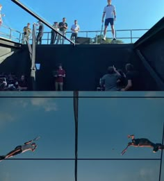 people are standing on top of a building and watching something in the air while others watch