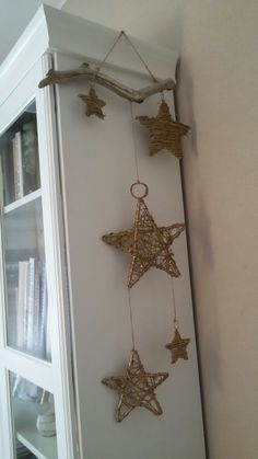 three gold stars hanging on a wall next to a book shelf