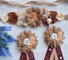 three ribbons with flowers on them are displayed next to some ribbon and other items that have been made out of paper