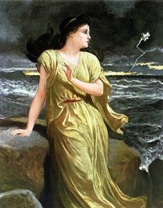 a woman standing on top of a cliff next to the ocean