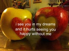 two apples with hearts on them sitting next to each other