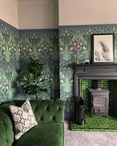 a green couch sitting next to a fireplace in a living room