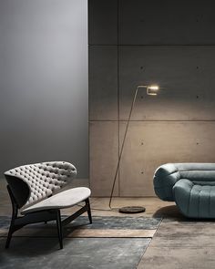 a living room filled with furniture and a lamp on top of a table next to a chair