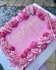 a birthday cake with pink frosting and flowers