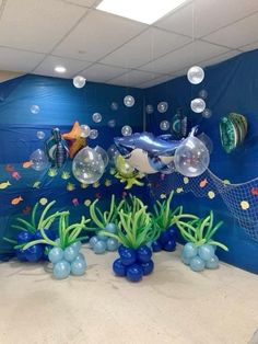 an ocean scene with fish, bubbles and seaweed in front of a blue wall