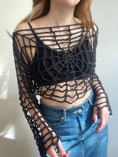 a woman wearing a black crop top and jeans