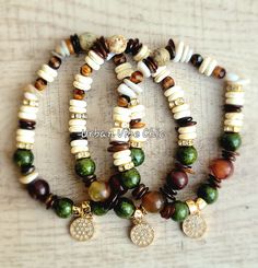 three different bracelets with charms on top of each other, one is green and the other is brown