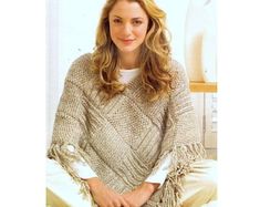 a woman sitting on a bed wearing a sweater