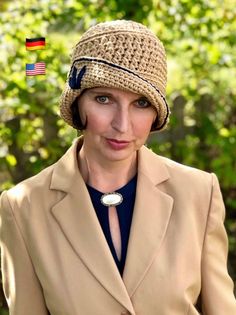 a woman wearing a hat and jacket in front of trees