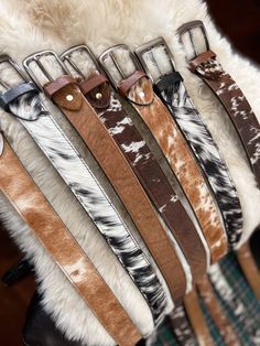 "Genuine cowhide and leather belts. Available in 29\" , 34\", 38\", 40\", and 42\"  Available in 3 color options." Cowhide Ideas, Cowhide Crafts, Cowhide Accessories, Cowhide Decor, Cowhide Belt, Bell Boots, Polo Wraps, Tooled Leather Belts, Western Shop