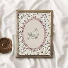 there is a framed picture with a duck on it next to an object that looks like a button