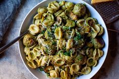 a white bowl filled with pasta and broccoli