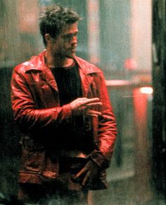 a man in a red leather jacket talking to someone