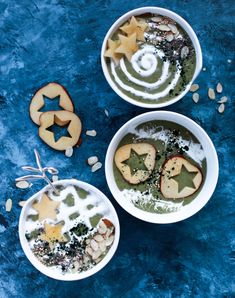 two white bowls filled with food on top of a blue tablecloth and surrounded by star shaped cookies