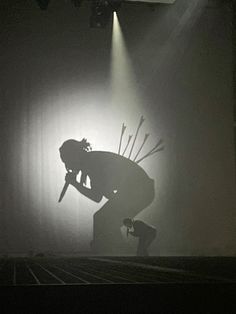 a person kneeling down in front of a spotlight