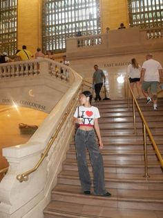 a woman standing at the bottom of some stairs