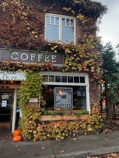 an old building with ivy growing on it's side and a sign that says coffee