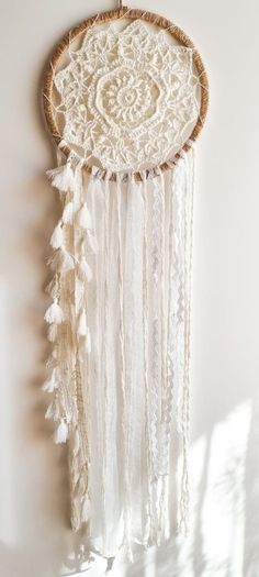 a white dream catcher hanging on the wall