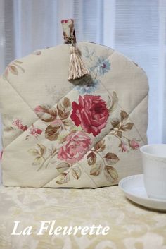 a purse sitting on top of a table next to a cup and saucer