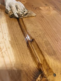 a pair of gloves sitting on top of a wooden floor next to a wet cloth