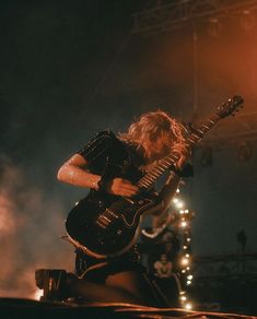 a man playing an electric guitar on stage