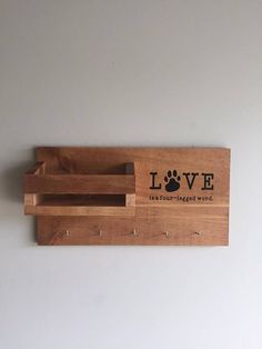 a wooden sign with a dog's paw on it that says love and is mounted to the wall