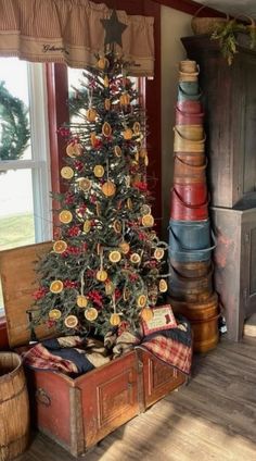 a small christmas tree sitting in the corner of a room next to an old trunk