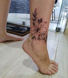 a woman's foot with a flower tattoo on her left ankle and the bottom part of her leg