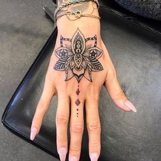 a woman's hand with a tattoo on it and a ring around her finger