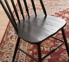 a wooden chair sitting on top of a rug