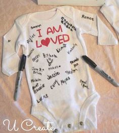 a baby's bodysuit with writing on it next to a sign that says i am loved