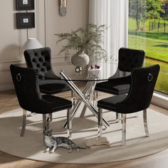 a dining room table with chairs and a cat laying on the floor in front of it