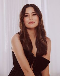 a woman in a black dress posing for a photo